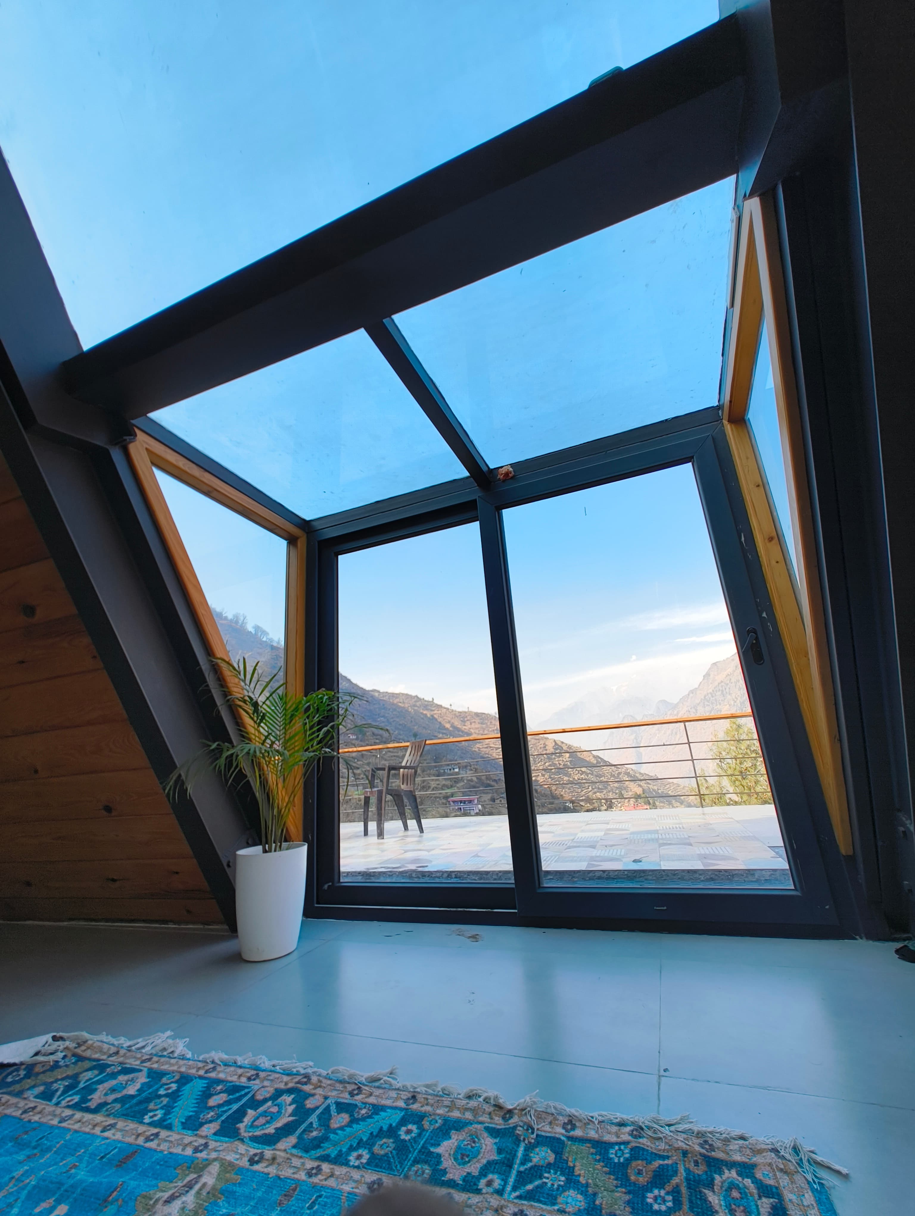 Sky View balcony — open glass doors framing the Himalayan range
