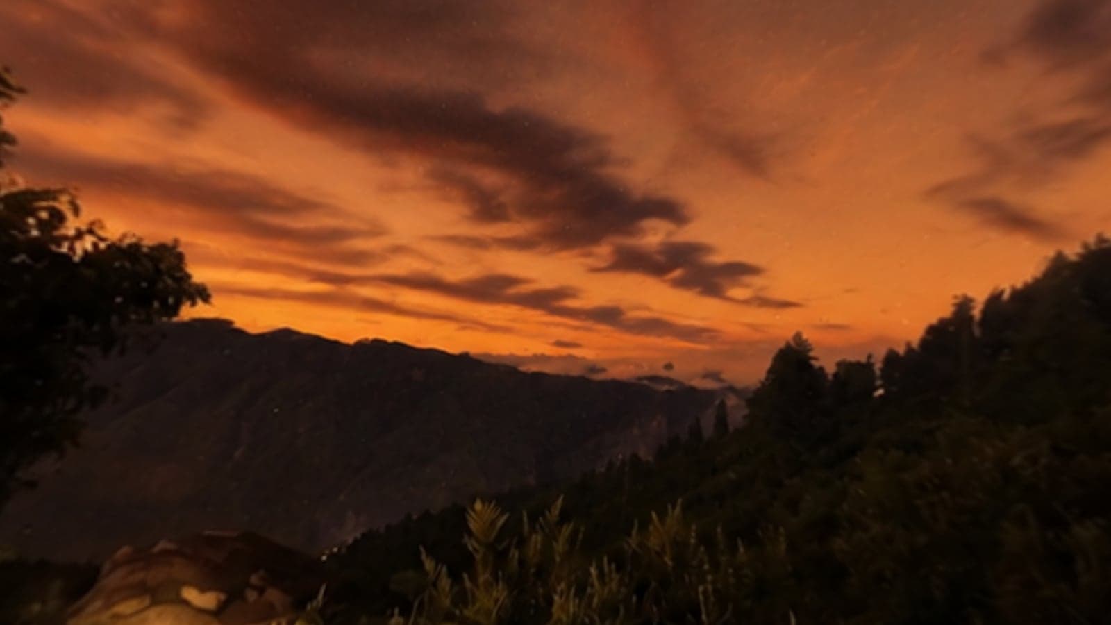 A 360 view from Vaadi at dusk, orange light behind layered Himalayan ridges
